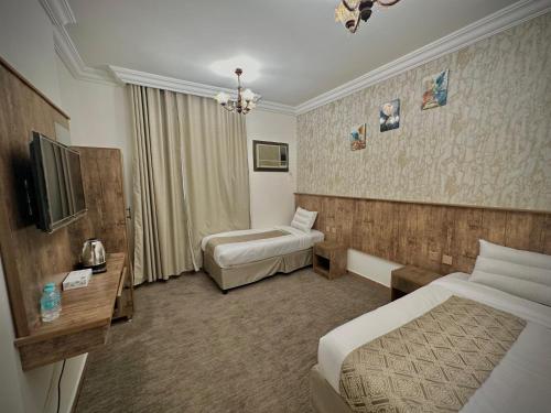 a hotel room with two beds and a television at فندق نجمة إسراء in Mecca