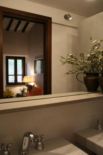 a bathroom with a mirror and a sink with a sink at Podere Marella in I Pieracci