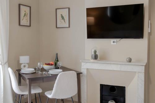 une salle à manger avec une table et une cheminée avec une télévision dans l'établissement Renovated 1-Br Apartment Heart of Cannes, à Cannes