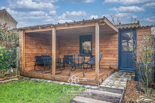 un hangar en bois avec des chaises et une table. dans l'établissement Évasion au Mans - Terrasse & Garage - L'Instant Clef, au Mans