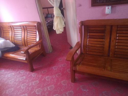 a bedroom with two wooden chairs and a bed at Homestay Ria in Kuala Lumpur