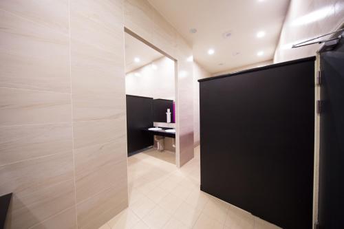a bathroom with a black door and a sink at SleepBox Hostel in Taipei