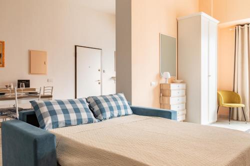 Un dormitorio con una cama y un sofá azul. en Open Space a 1' dalla Stazione, en La Spezia