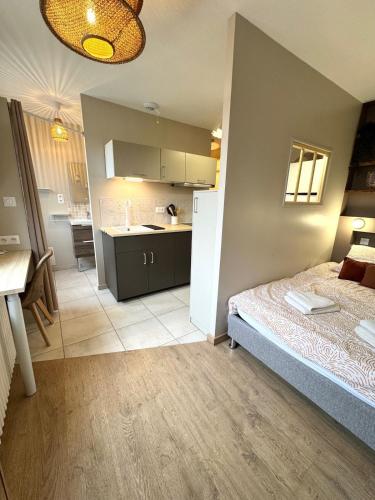 une petite chambre avec un lit et une cuisine dans l'établissement La Cachette, à Dijon