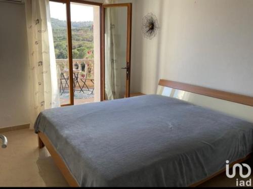 Un dormitorio con una cama y vista a un balcón. en Chambre villa Soleil, en Roquebrune-sur-Argens