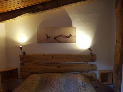 - une chambre avec un lit et deux lumières sur le mur dans l'établissement Gîte du bout du monde La Bergerie, à Barrême