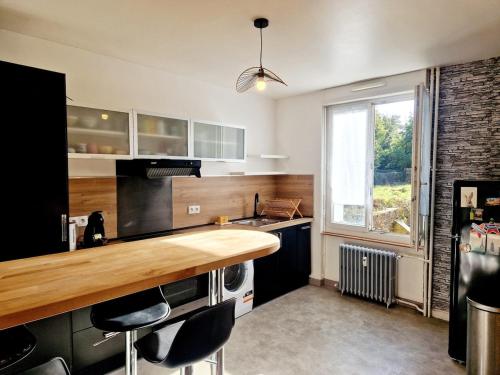 une cuisine avec un comptoir en bois et une fenêtre dans l'établissement La Porte Du Midi, à Cherbourg en Cotentin