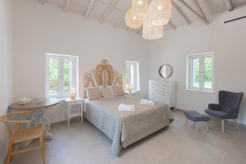 a bedroom with a bed and a table and a chair at Spacious House with Cottage&Pool in Nafplio