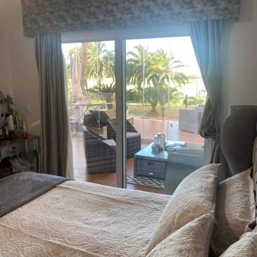 a bedroom with a bed and a view of a patio at Casa Paradise 2, Ground Floor Apartment on Mar Menor Golf Resort in Torre-Pacheco