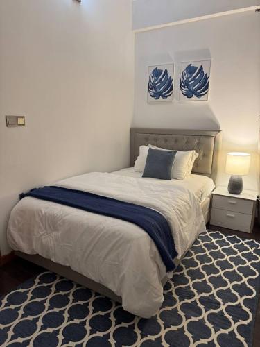 a bedroom with a large bed and a blue and white rug at Nalahost 2BR Seaview Terrace apartment in Male City
