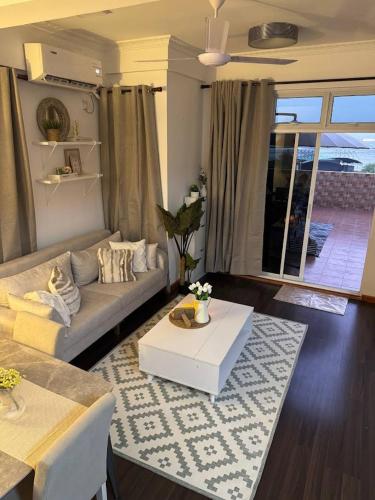 a living room with a couch and a table at Nalahost 2BR Seaview Terrace apartment in Male City