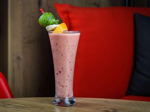 a glass filled with a pink drink on a table at Ibis Sfax in Sfax