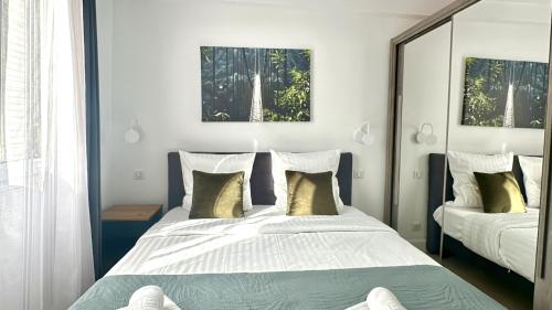 une chambre avec deux lits et un miroir dans l'établissement Mike by Terry's Homes, à Cannes