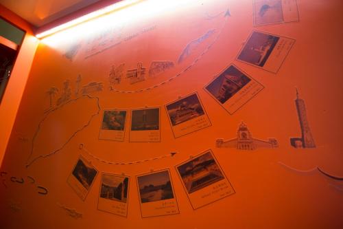 a wall with pictures and pictures on it at SleepBox Hostel in Taipei
