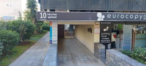 a store with a sign on the side of a building at Glyfada Path of Poets in Athens