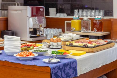 a buffet of food on a table with plates of food at Garni Hotel Azul in Kranj