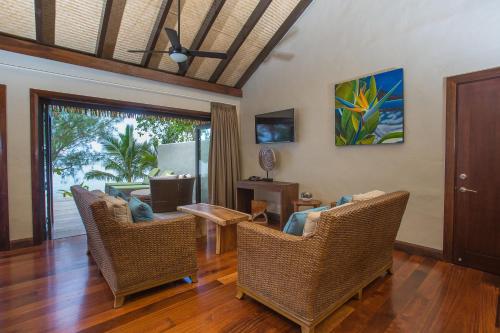uma sala de estar com cadeiras de vime e uma mesa em Nautilus Resort em Rarotonga