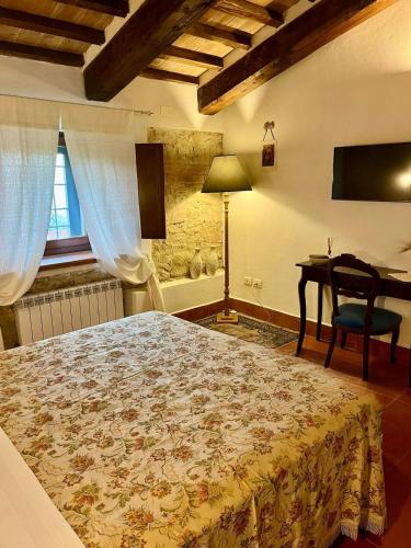 a bedroom with a bed and a table and a desk at Casale Delle Stelle in Castello delle Forme