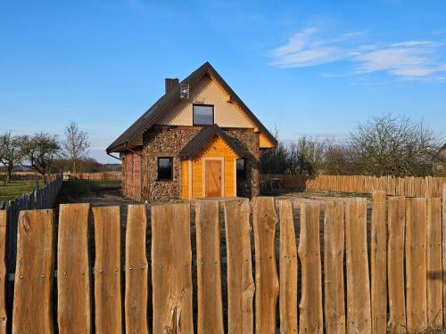 a house behind a wooden fence behind a fence at Okoń in Sztabin