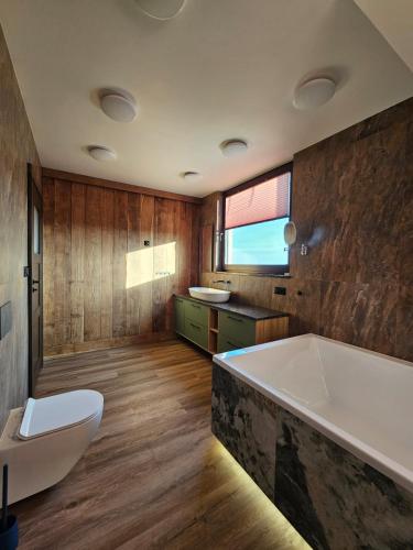 a bathroom with a tub and a toilet and a sink at Okoń in Sztabin