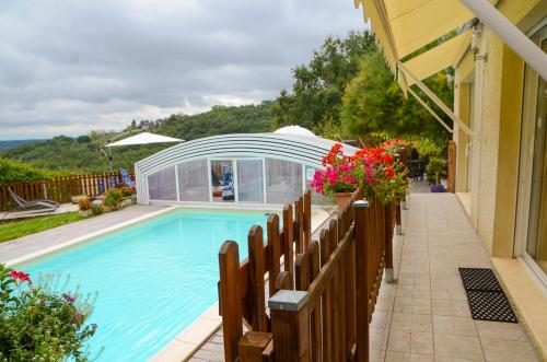 una piscina junto a una casa con una valla y flores en Domaine de la Moretie, en Cublac