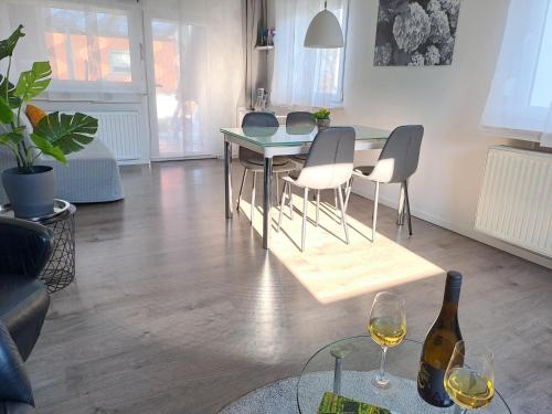 a living room with a table and chairs and a bottle of wine at Hortensie Speyer in Speyer