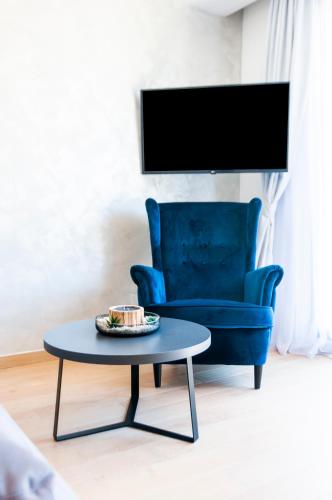 a living room with a blue chair and a table at Apartments with private jacuzzi Garbin 1 and Garbin 2 in Rovinj