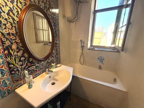 a bathroom with a sink and a mirror and a tub at Suite Vecchio Frantoio - Sanremo in Sanremo