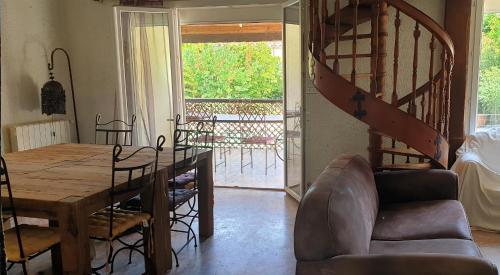 - un salon avec une table en bois et un escalier dans l'établissement villapiscineXL, à Montady