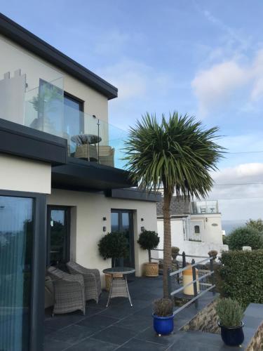 a house with a palm tree on a patio at Mevagissey Boutique Flatlet with sea and countryside views in Mevagissey