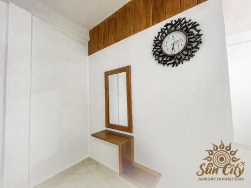 a stairwell with a mirror and a clock on a wall at SunCity Airport Transit Stay in Minuwangoda
