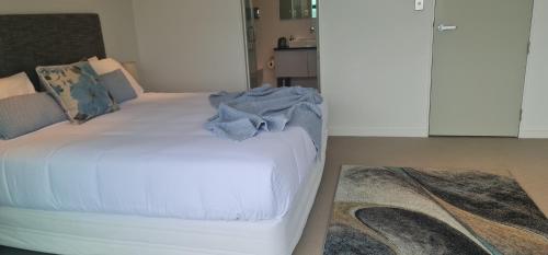 a bedroom with a white bed and a rug at Villa 3 Luxe Coastal Escape in Cable Bay