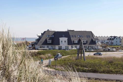 a large house sitting on the side of a beach at TUI BLUE Sylt in Rantum