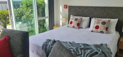 a bedroom with a large bed and a window at Villa 3 Luxe Coastal Escape in Cable Bay