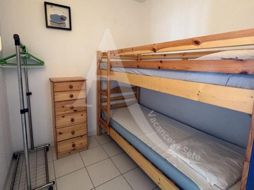 Cette chambre dispose de lits superposés avec 2 lits superposés et une commode. dans l'établissement 1 CHAMBRE, VUE MER, ACCES DIRECT PLAGE, à Sète