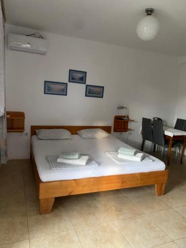 a bedroom with a bed and a table and chairs at Vila Mila in Petrovac na Moru