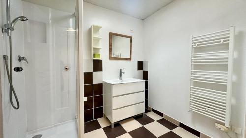 une salle de bain blanche avec un lavabo et une douche dans l'établissement Le Nid du Lac, à La Chevrolière