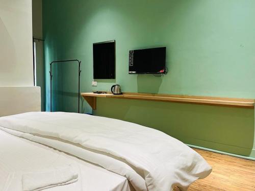 een slaapkamer met een bed en een tv aan de muur bij MY ROOMZ BANARAS in Varanasi