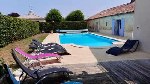 - un groupe de chaises et une piscine dans l'établissement Glycine, 6 person cottage, à Nalliers