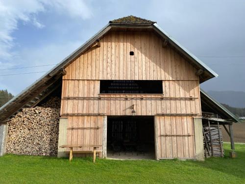 a large wooden barn with a large door at Temelhof - Landhaus mit Sauna und Kamin in Sittersdorf