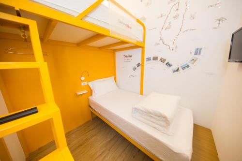 a bunk bed in a small room with yellow walls at SleepBox Hostel in Taipei