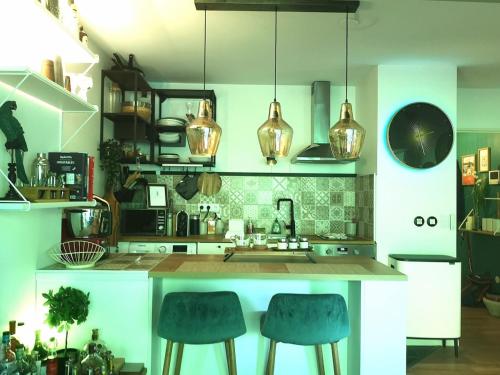 - une cuisine avec deux tabourets de bar bleus et un comptoir dans l'établissement Appartement cosy proche Centre des congrès et Transbordeur, à Caluire-et-Cuire
