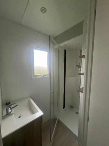 une salle de bain blanche avec un lavabo et une douche dans l'établissement Camping Lizoé, à Pont-Croix
