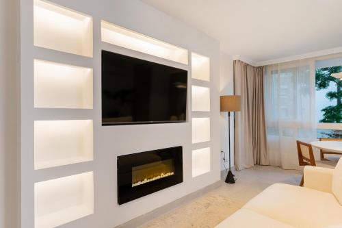 sala de estar con chimenea y TV en la pared en MONKÓ LUXURy EGYPT, en Torremolinos
