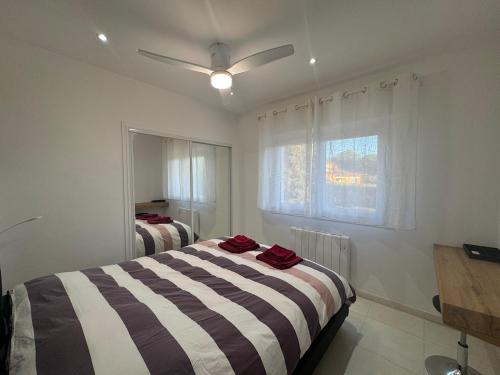 une chambre avec deux lits et un ventilateur de plafond dans l'établissement Appartement 2ch avec terrasse à 400m de la plage, à Cavalaire-sur-Mer