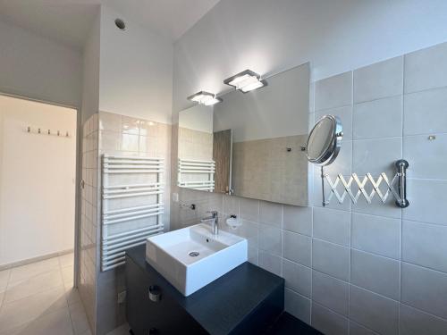 une salle de bain avec un lavabo blanc et un miroir dans l'établissement Appartement 2ch avec terrasse à 400m de la plage, à Cavalaire-sur-Mer
