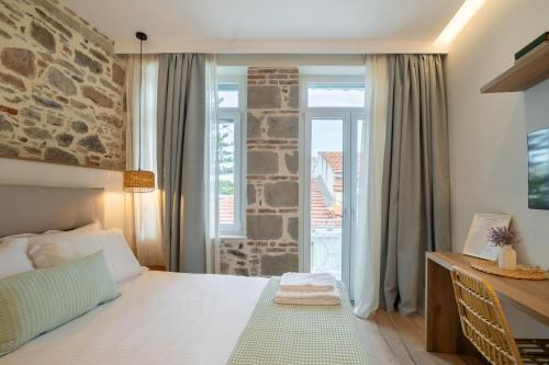 a bedroom with a bed and a stone wall at Τhe 1930s in Mytilini