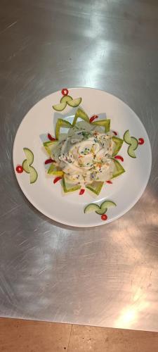 a white plate with apple slices on a table at Lamahatta Clouds Hotel & Restaurant in Takdāh