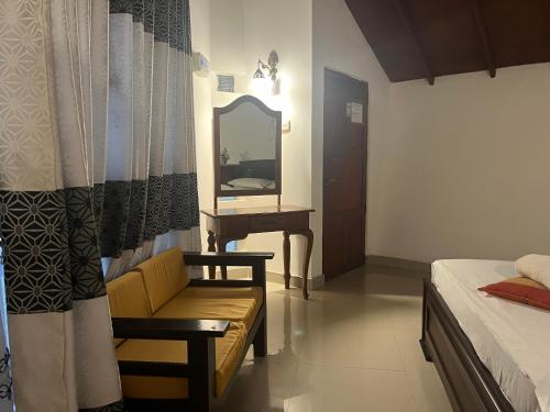 a bedroom with a mirror and a chair and a bed at Royal Green Garden - Puttalam in Puttalam