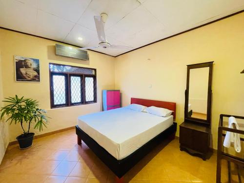 a bedroom with a bed and a mirror in it at Gee Hills in Weligama